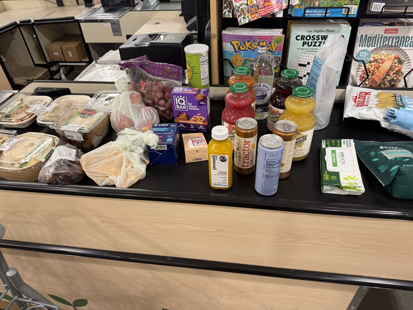 Grocery haul flat lay on a checkout counter, shot at Sprouts before a run